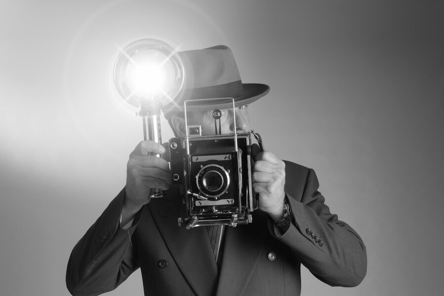 foto antigua con hombre que sujeta cámara con flash